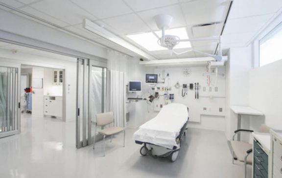 A clean, white hospital room with an empty bed.