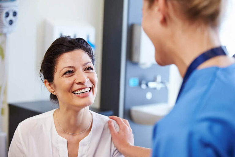 A female patient smiles at a doctor.